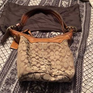 A Coach bag with leather trim and handles, it’s a bucket style purse